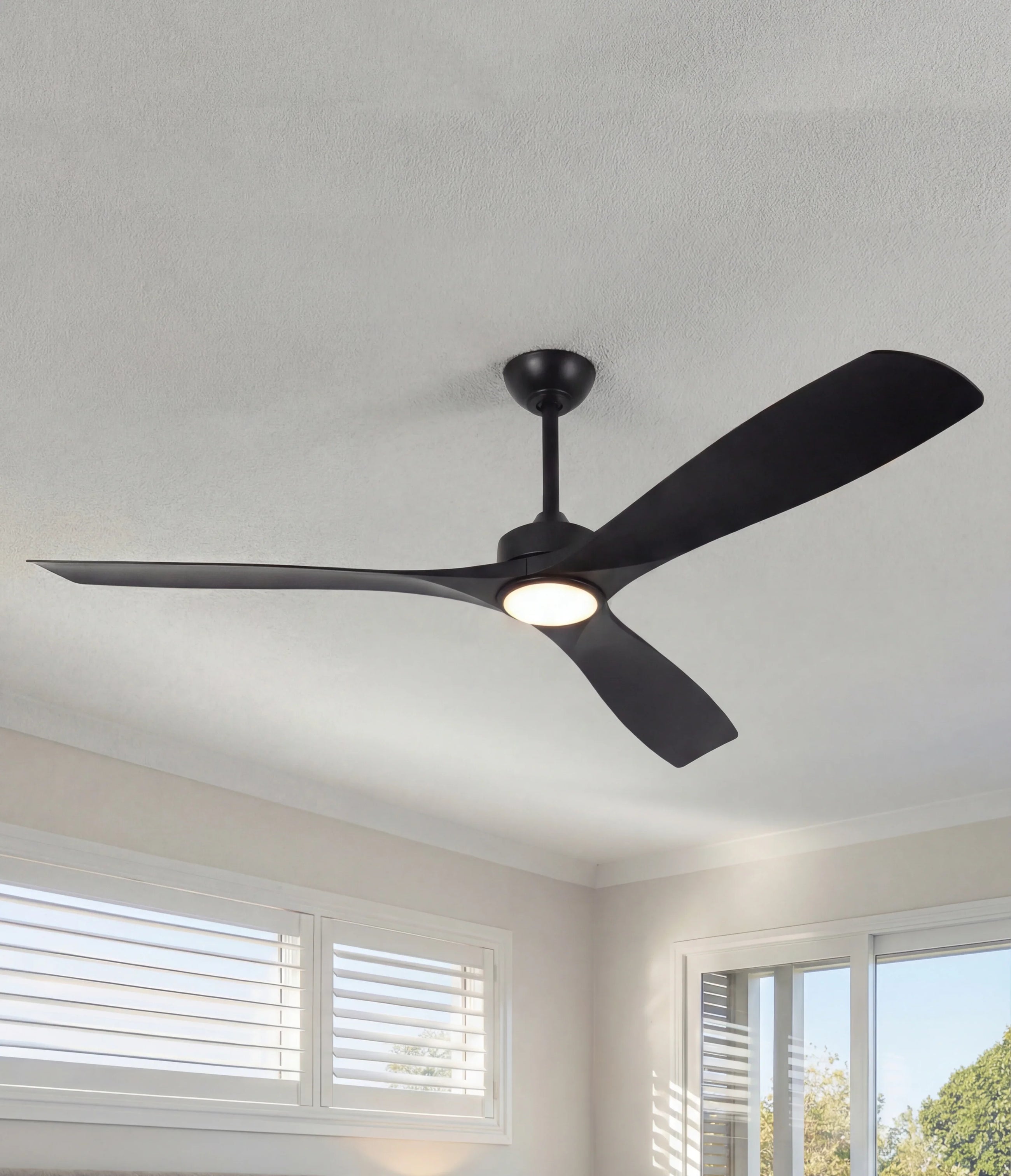 Modern black ceiling fan with integrated LED light in a bright, contemporary bedroom