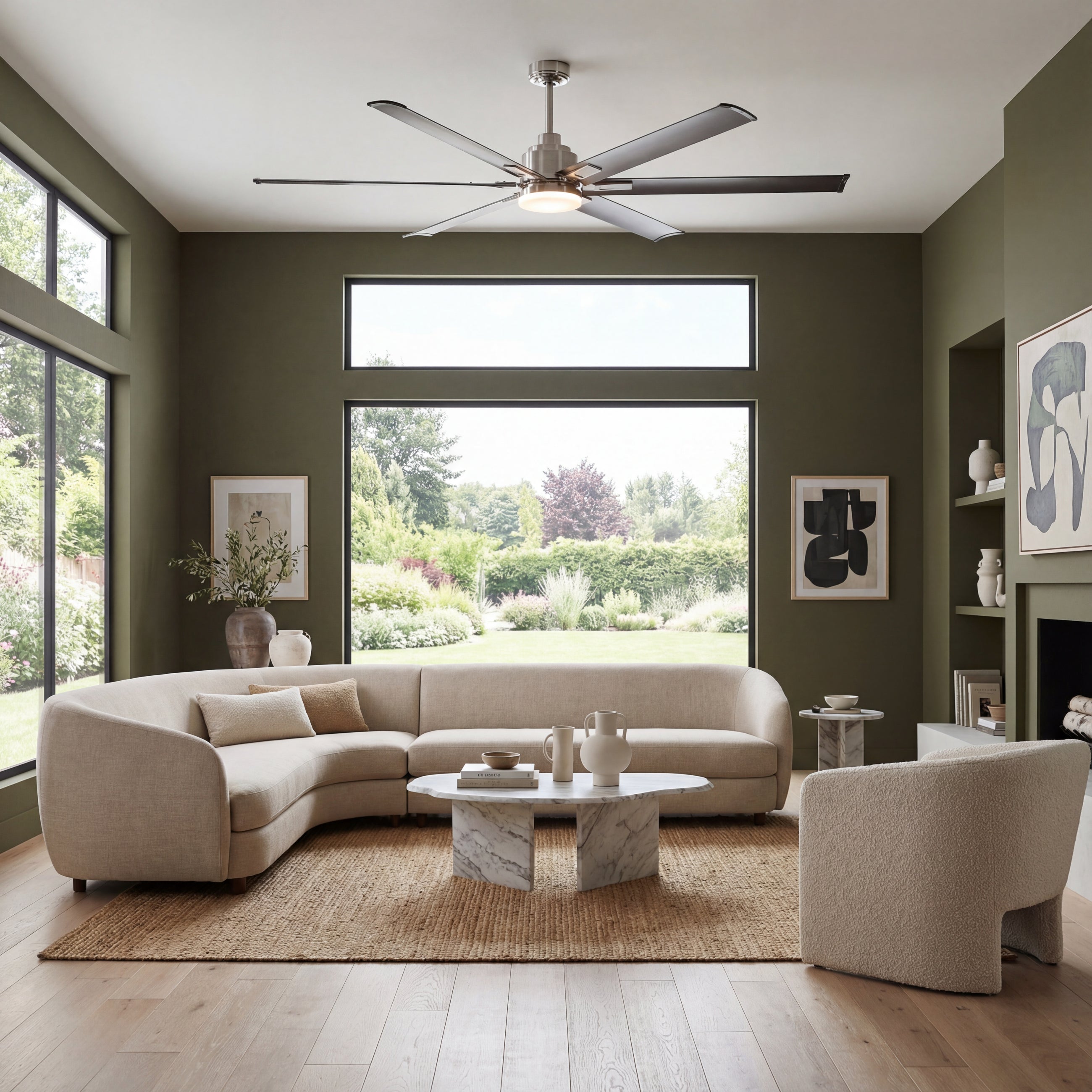 Modern living room with large windows, neutral sectional sofa, and a sleek ceiling fan with light.