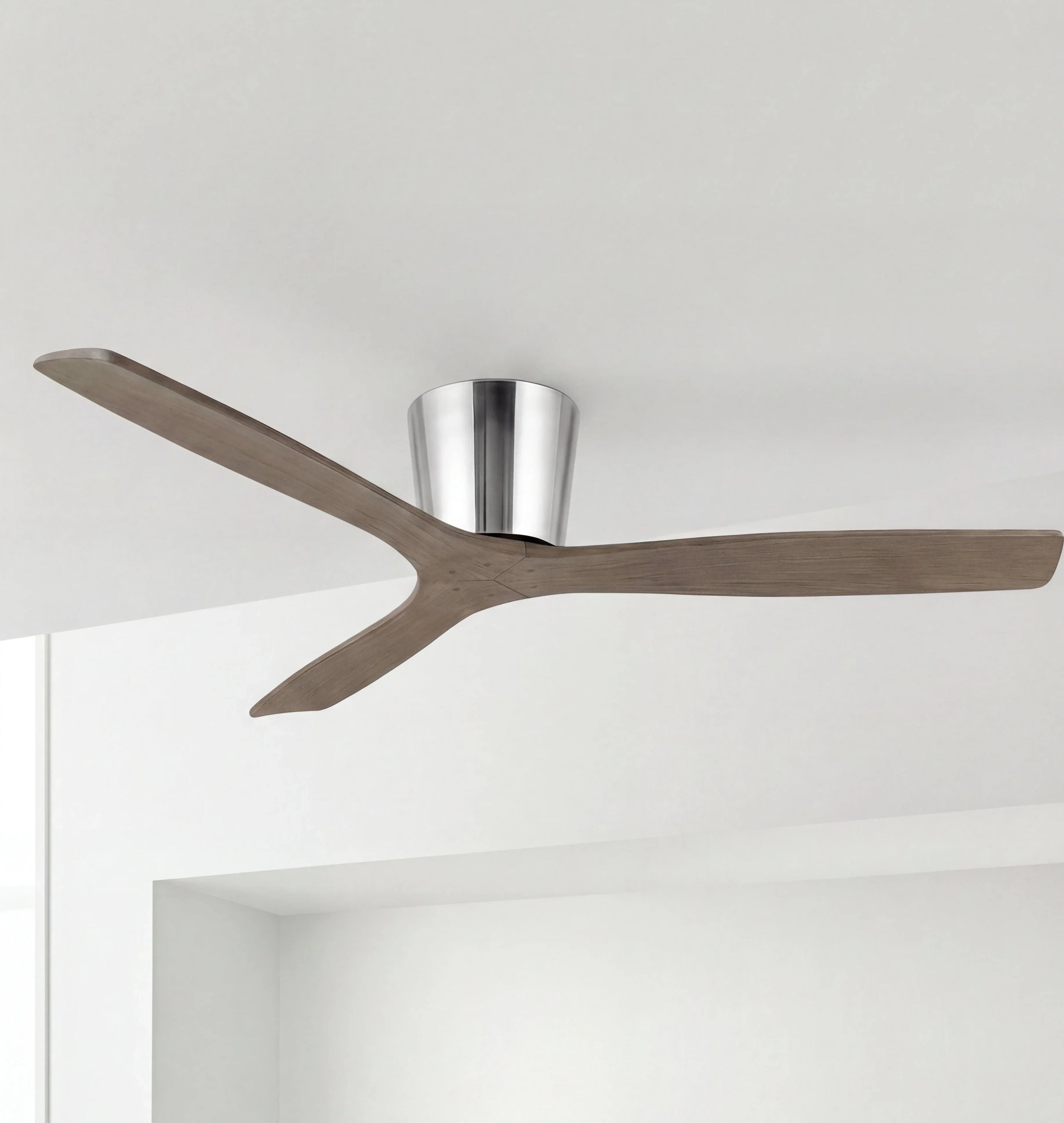 Modern wood ceiling fan with three blades and brushed metal mount in a minimalist room