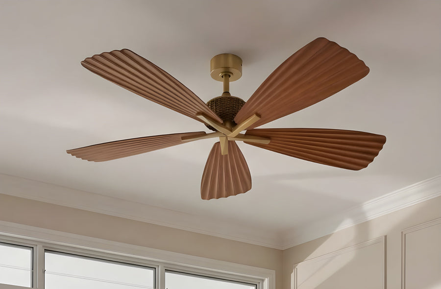 Modern wood ceiling fan with five sculpted blades and gold accent, mounted in a bright room