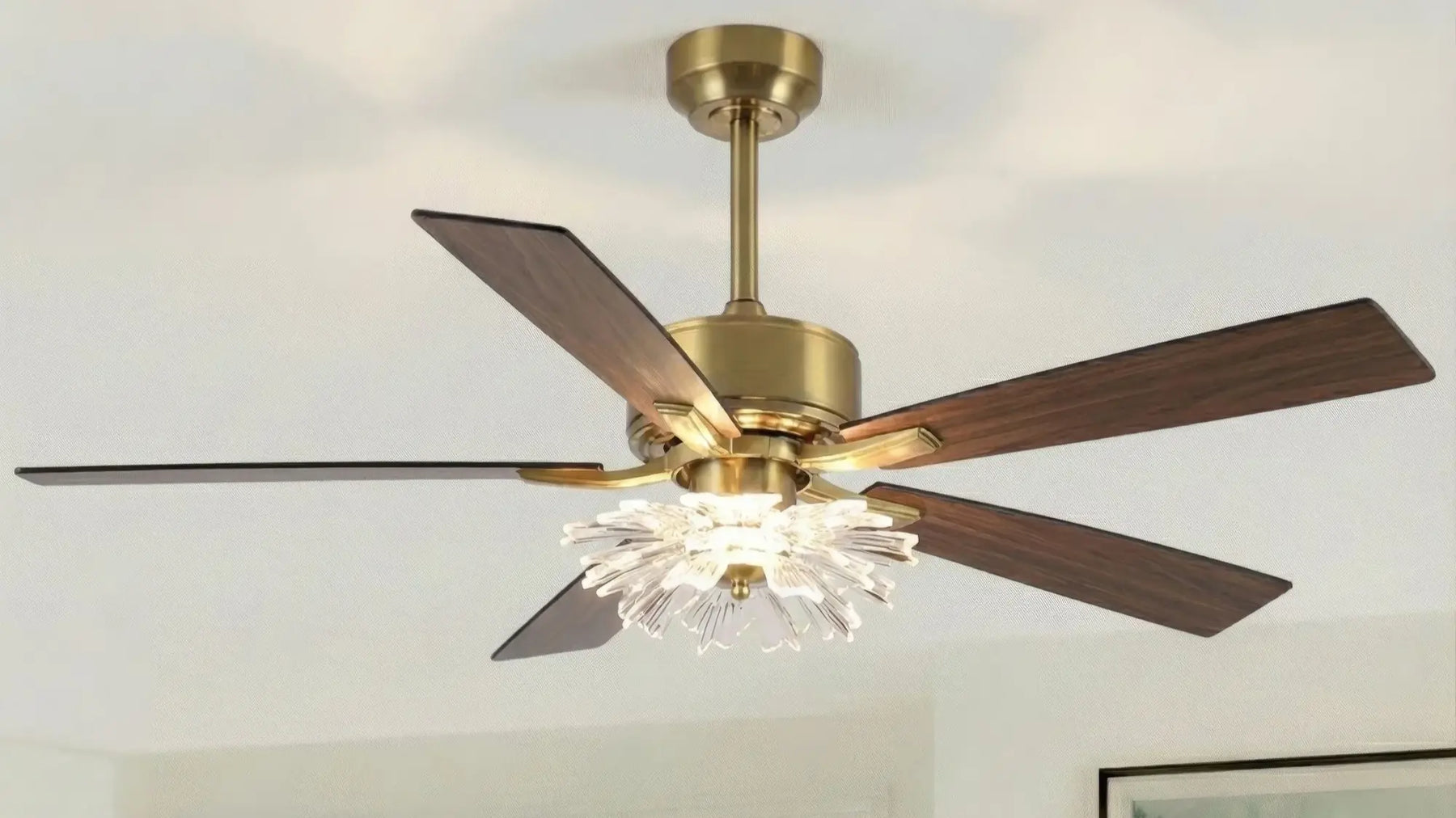 Modern gold ceiling fan with wood blades and crystal chandelier light fixture.