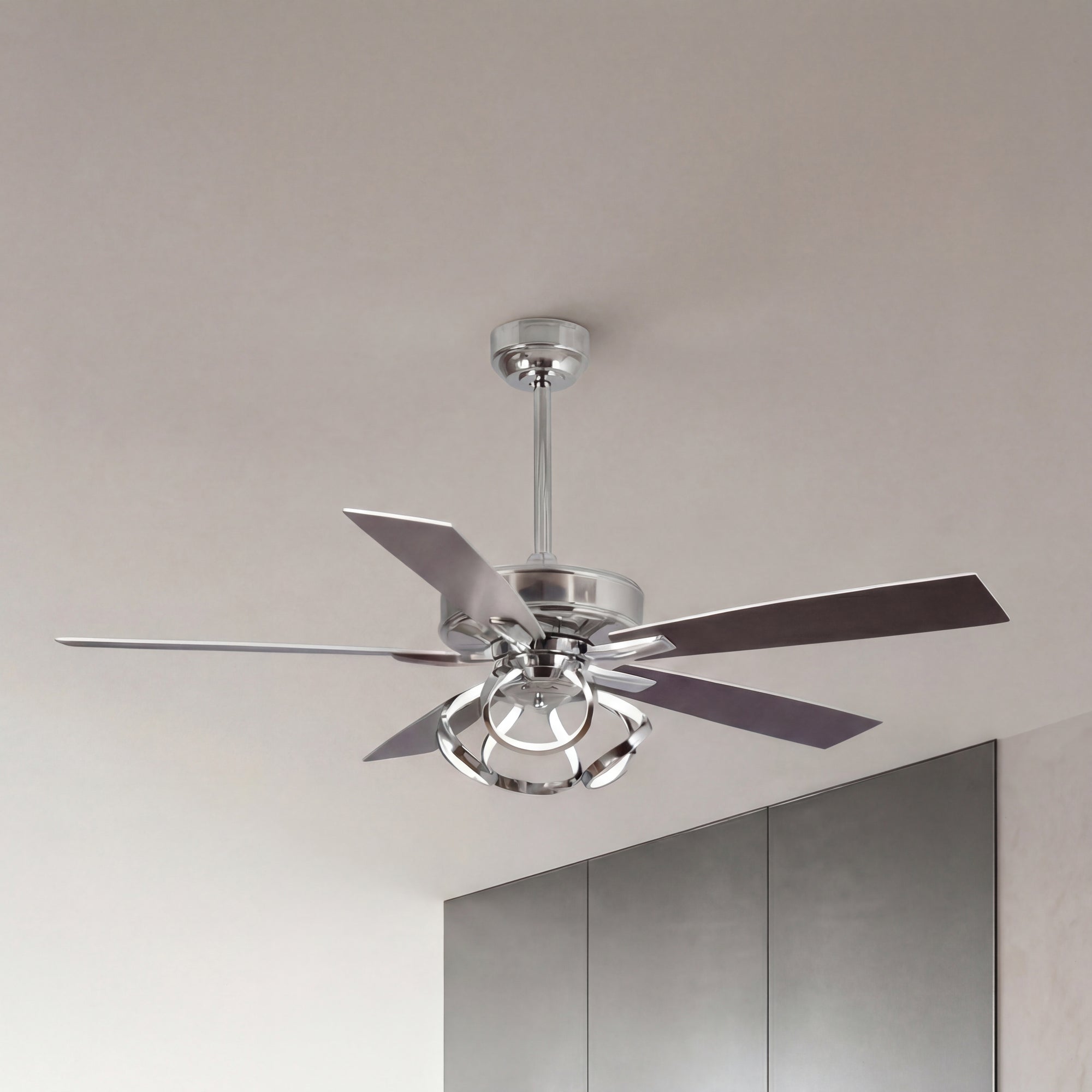 Modern silver ceiling fan with sleek blades and integrated light fixture in a minimalist room