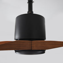 Modern ceiling fan with dark metal housing and wood blades, close-up view
