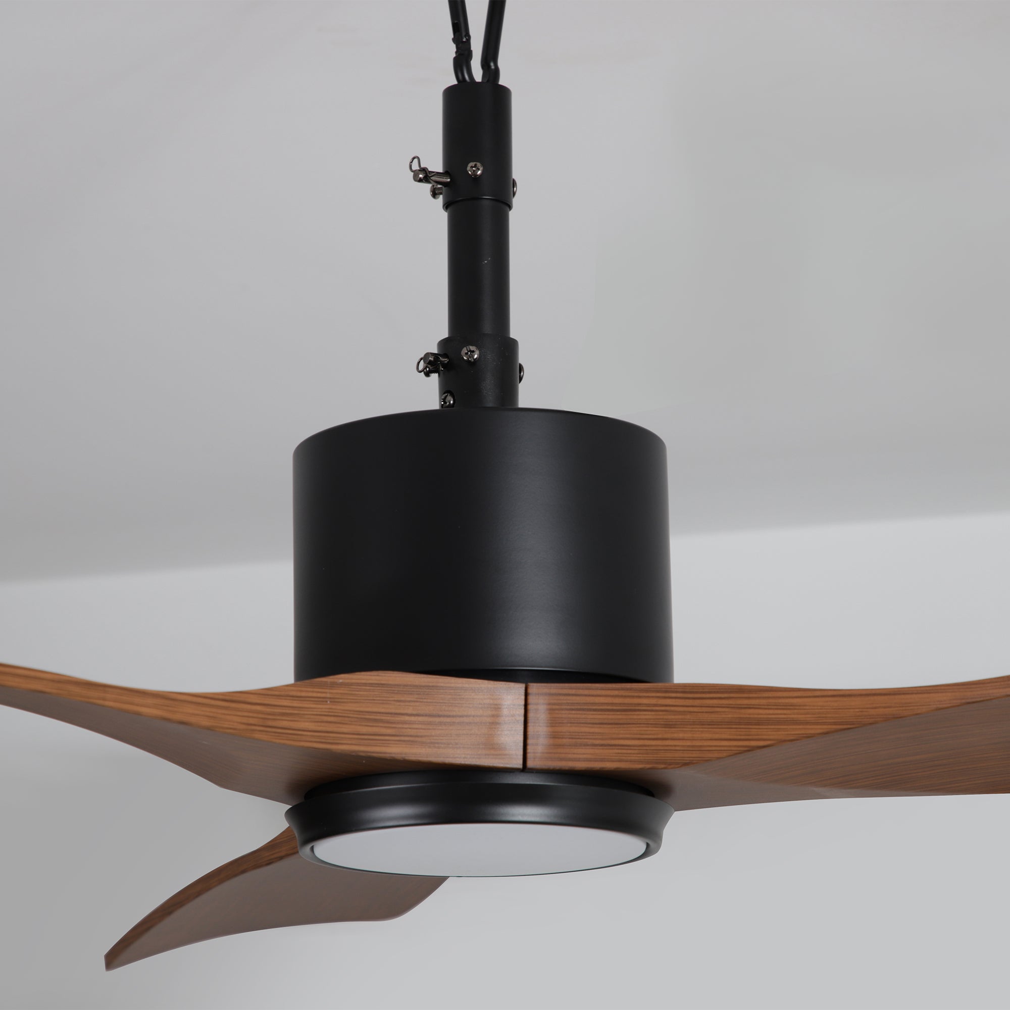 Modern ceiling fan with wood blades and black motor housing, integrated LED light