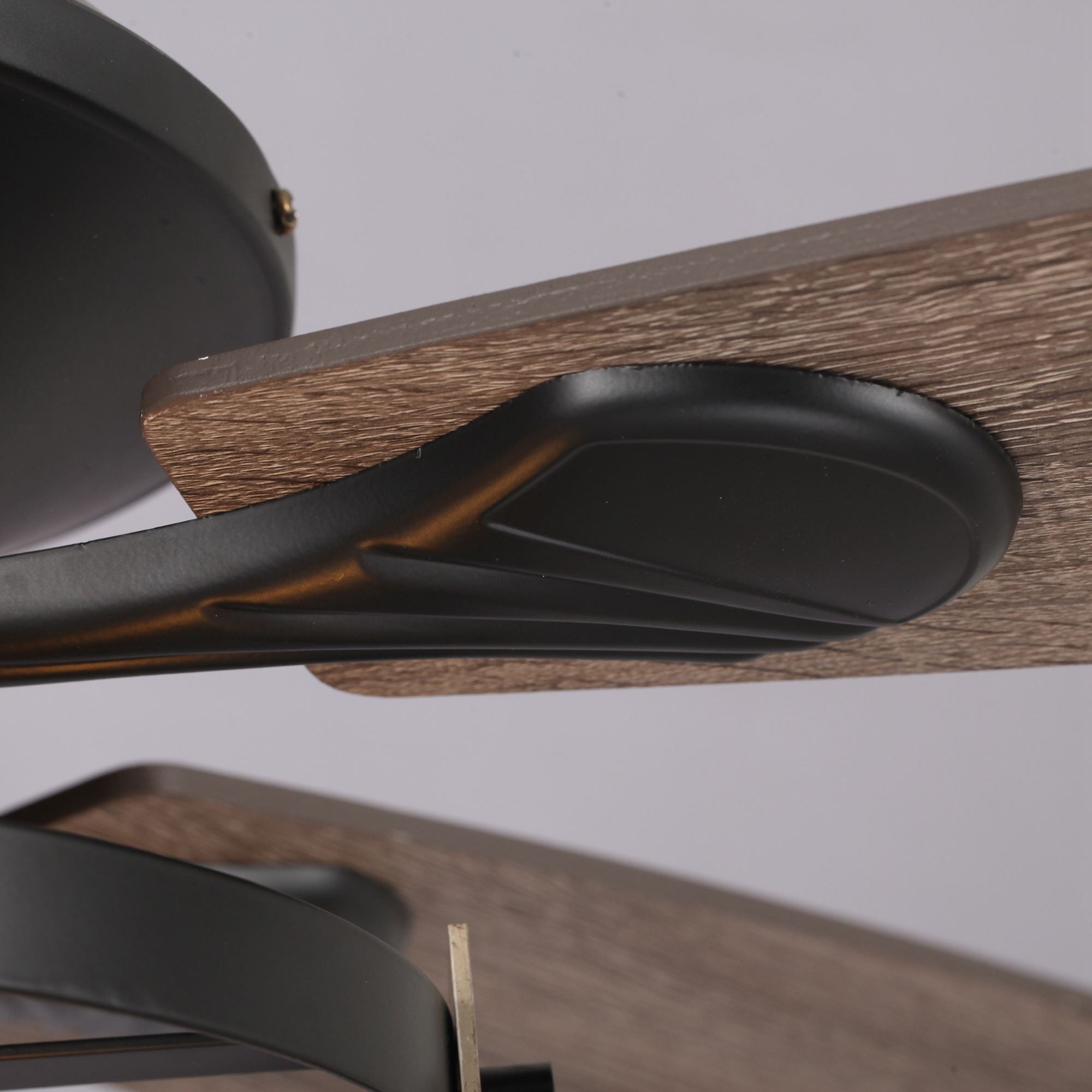Close-up of modern wood and black metal ceiling fan blade detail