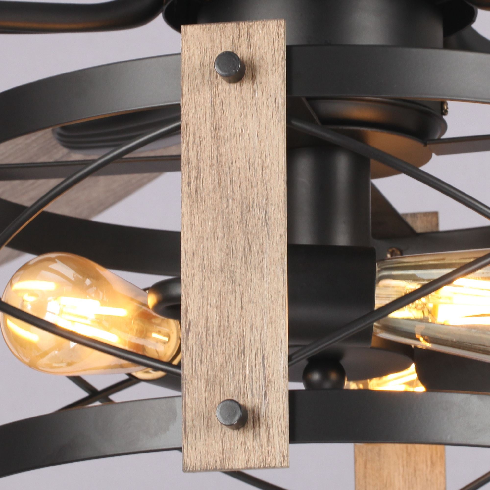 Close-up of modern industrial ceiling fan with exposed bulbs, wood and black metal details