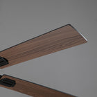 Close-up of modern ceiling fan blades with a wood finish against a gray background